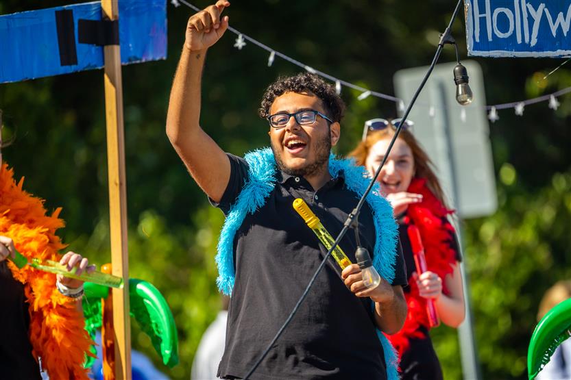 A student rides on a homecoming parade float